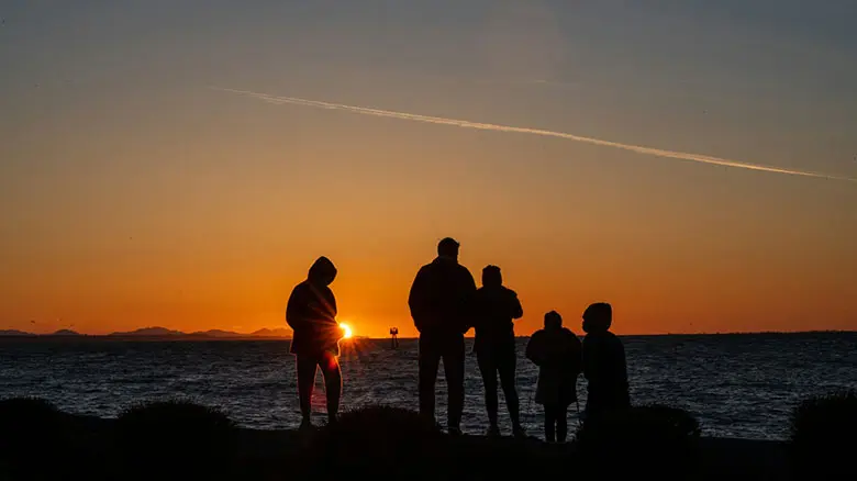 Family enjoying a peaceful retreat together, relaxing outdoors in a natural or cozy setting.