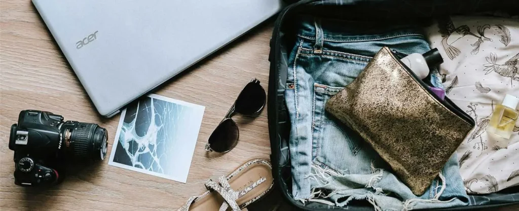 Travel tips displayed with a suitcase, passport, and travel accessories on a wooden table