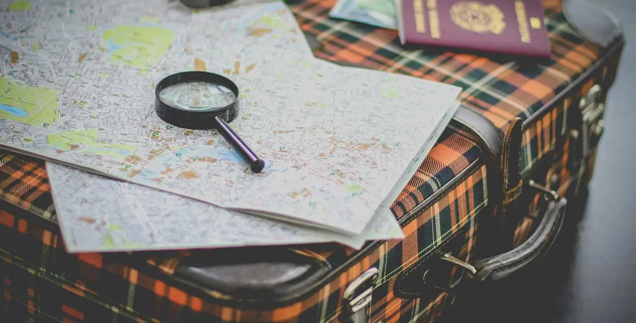 Travel tips displayed with a suitcase, passport, and travel accessories on a wooden table